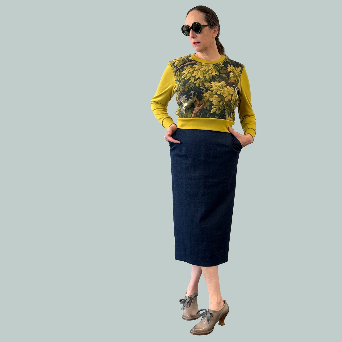 Cropped ladies' sweater with tapestry front and chartreuse Laurent Garigue wool sleeves and back, full body view with hands in pockets