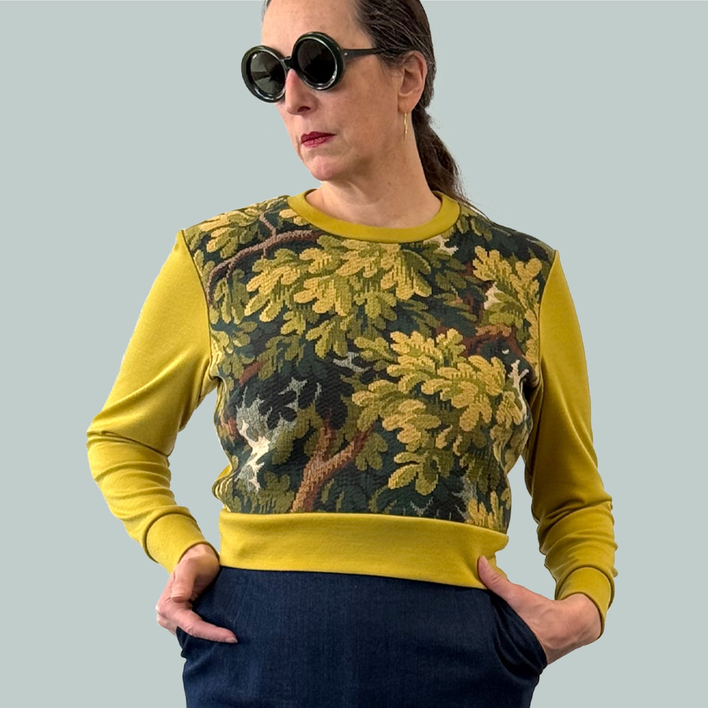 Cropped ladies' sweater with tapestry front and chartreuse Laurent Garigue wool sleeves and back, close up with hands in pockets