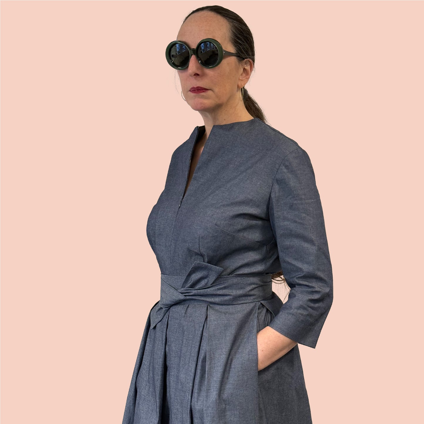 1950s inspired shirtwaist dress in denim chambray side view with hands in pockets