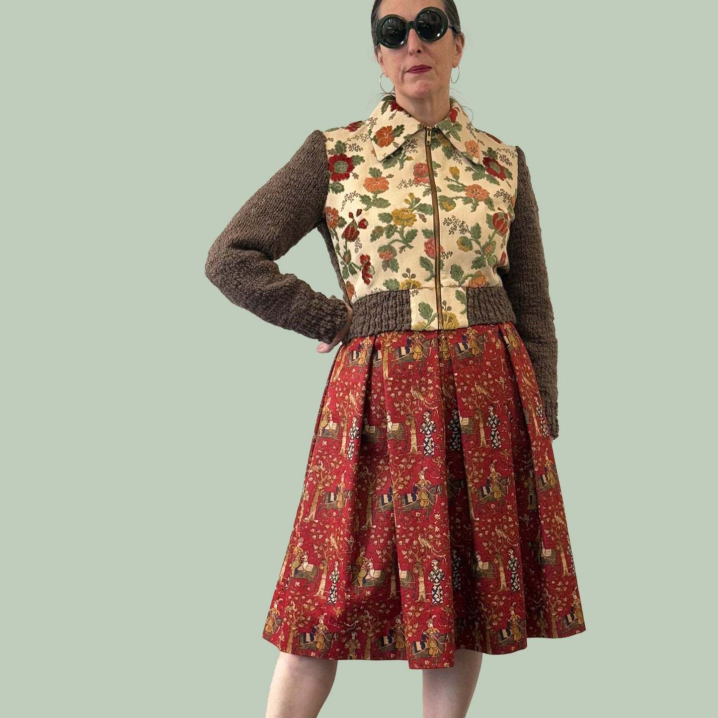 Ladies cropped jacket with vintage upholstery fabric front and hand knitted wool sleeves and back, worn with patterned dress